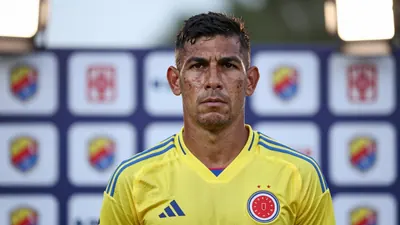 A 35-year-old Colombian midfielder, with a rugged, weathered face and a strong jawline, stands in front of a blurred...