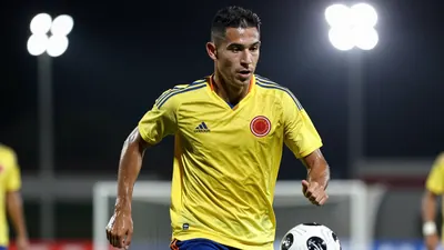 A 28-year-old Colombian midfielder in a solid yellow jersey, athletic build, running with the ball at his feet