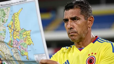 A close-up of a rugged, 35-year-old Colombian national team coach, with a weathered face and a few days' worth of...