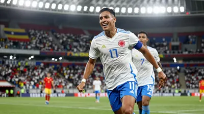 A photorealistic image of a Colombia national team player in a white jersey with a blue stripe, a blue pair of shorts...