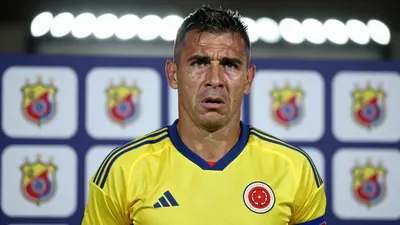 A 40-year-old former defender, with a strong build and rugged features, dressed in Colombia's yellow and blue home kit...