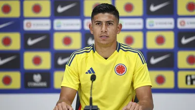 A Colombian national team player, mid-20s, athletic build, in the yellow and blue home kit with the Colombia crest...