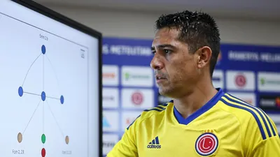 A close-up shot of a 25-year-old Colombian national team coach, wearing the official yellow and blue home kit of Los...