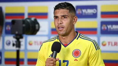 A Colombian national team player in the yellow and blue home kit, mid-30s, muscular build, wearing the Colombia crest on...