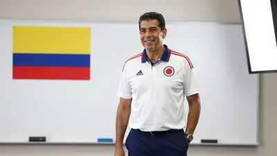 A photorealistic image of an anonymous Colombian national team coach in his mid-50s, with a kind expression, wearing a...